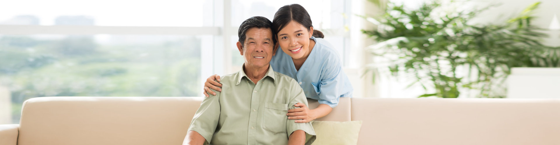 an elderly man with a caregiver woman smiling